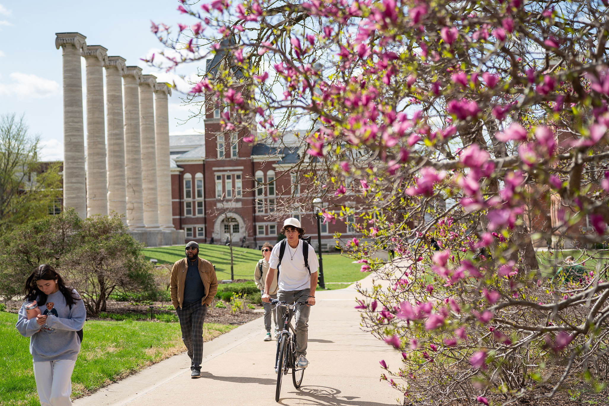 Springtime on the quad with students biking and walking
